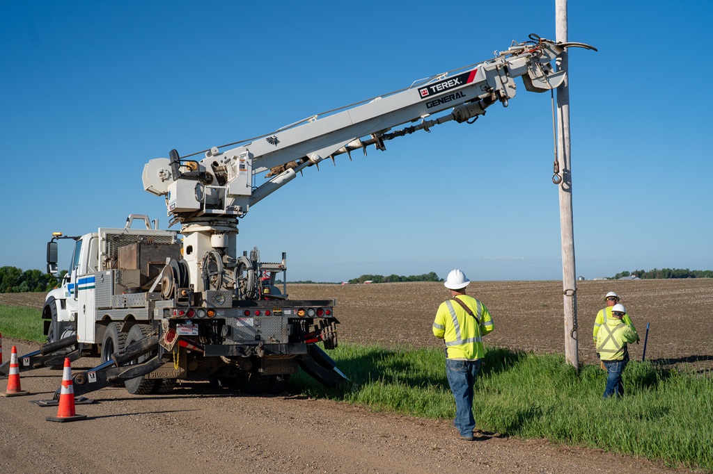 Lineworkers operating a digger derrick