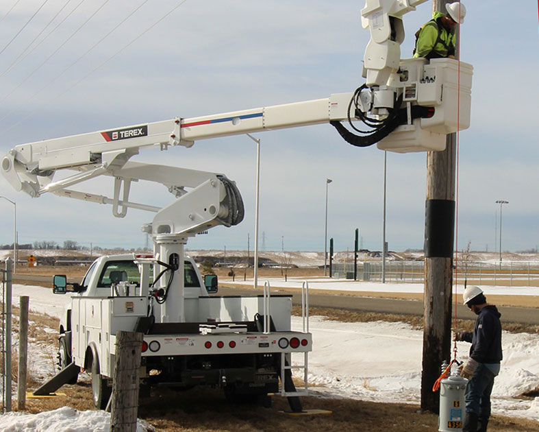 Utility worker lifting a transformer with a Terex bucket truck