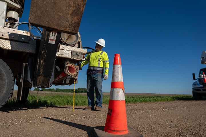 Utility worker operating Terex truck on side of road