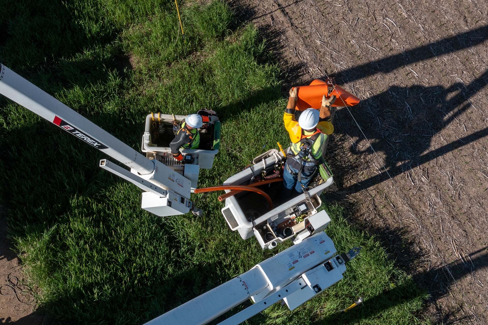 Overhead view of utility workers in Terex bucket trucks