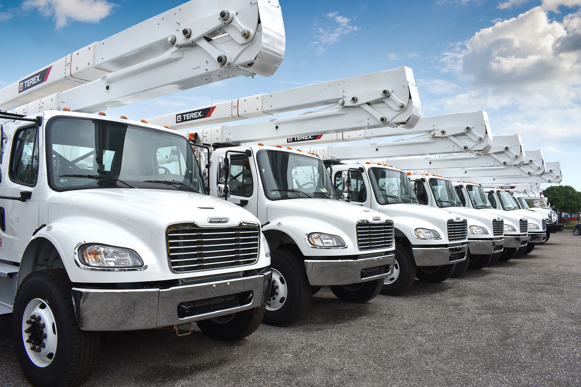 Terex bucket trucks lined up in parking lot for storm response